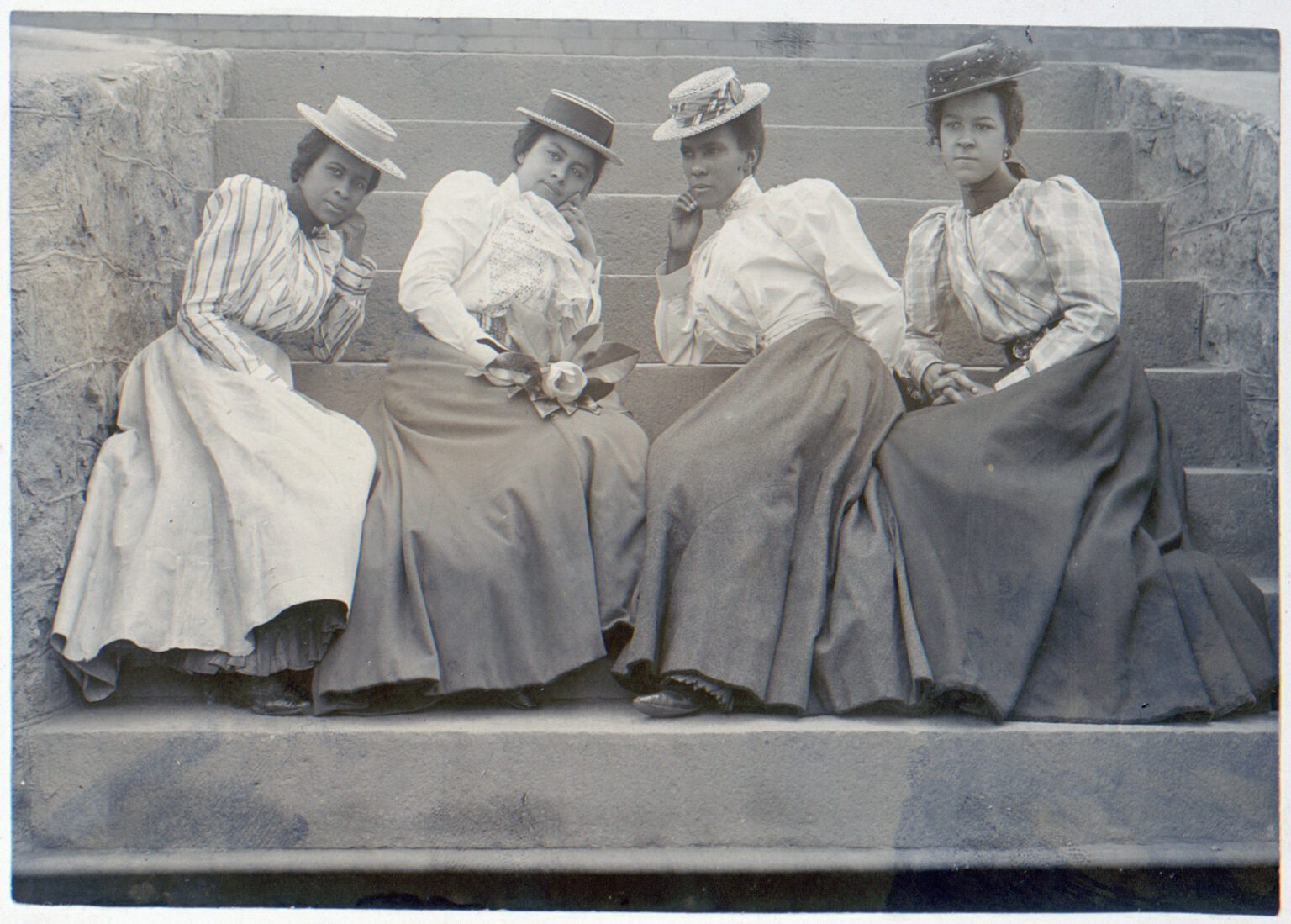 Four African American women seated on steps of building at Atlanta University, Georgia, Thomas E. Askew, 1899 or 1900, matte collodion silver print.